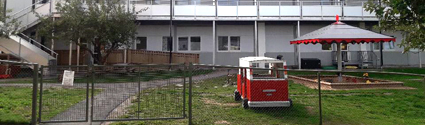 Gården vid Österfärnebo förskola med lekredskap och en ljus byggnad i bakgrunden