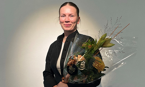 Porträtt foto på Kristin Sundberg med en blombukett i handen