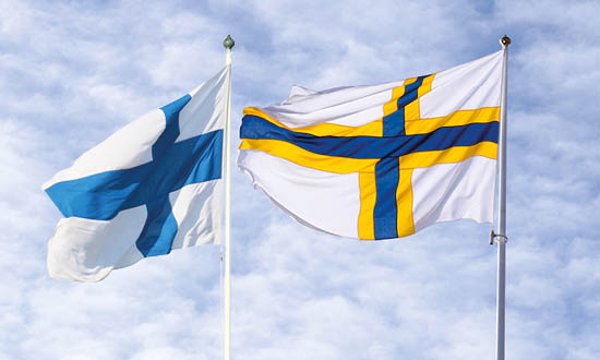 Den finska och sverigefinska flaggan vajar i vinden.