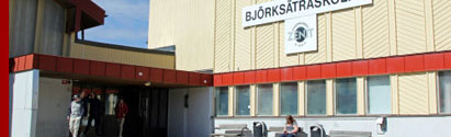 Björksätraskolans gula fasad med röda inslag samt en skylt Björksätraskolan