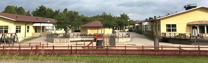 Några gula byggnader vid Hedängsskolan. Rött staket framför skolgården.