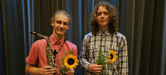 Stipendiater, två pojkar med blommor och en saxofon