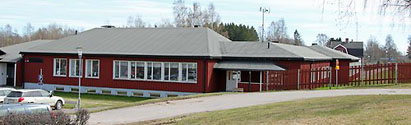 Rödmålad enplansbyggnad, del av Kungsgårdens skola. Framför skolan en cykelväg.