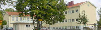 Sätra skola. Ett gult tvåvåningshus med ett stort träd framför
