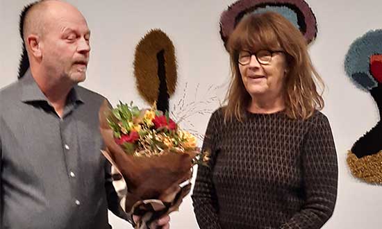 Foto på Conny Grönberg som ger en blombukett till kulturpristagaren Helene Rådberg